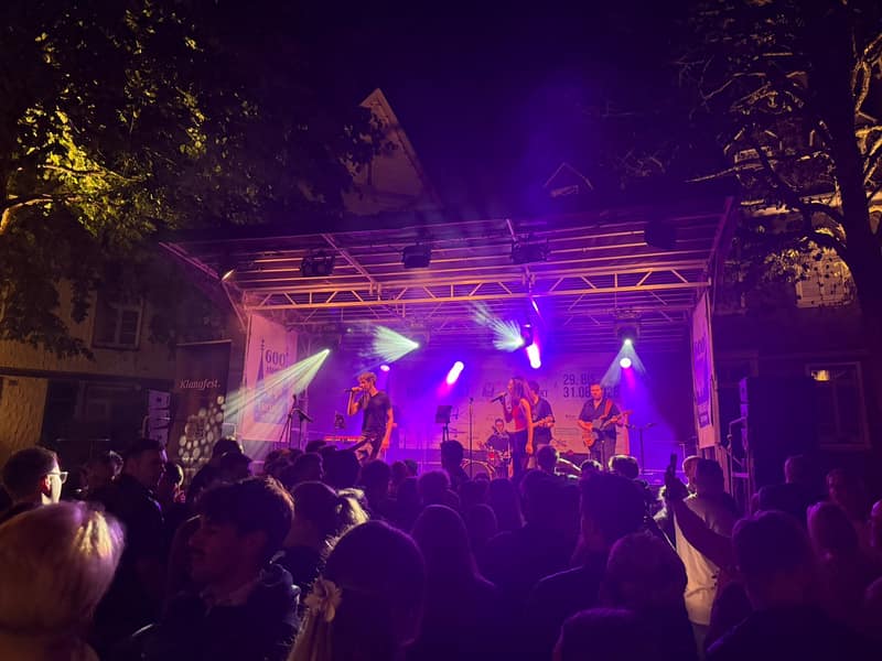 Freilichtbühne beim Stadtfest mit Live-Band, PA und violettem Bühnenlicht vor Publikum