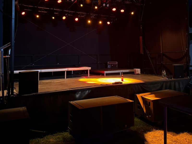 Aufgebautes Lichttechnik-Rig auf leerer Open-Air-Bühne vor Showbeginn